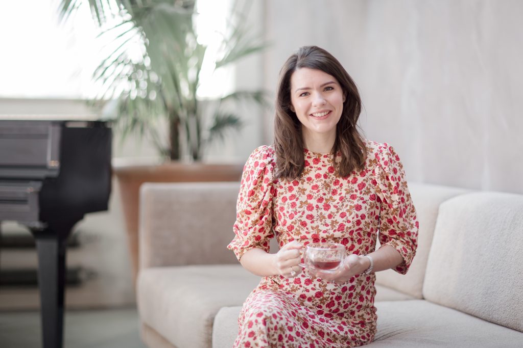 woman sitting on a couch holding a cup of tea