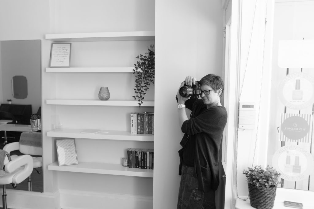 black and white image of a photographer taking a photo in a salon