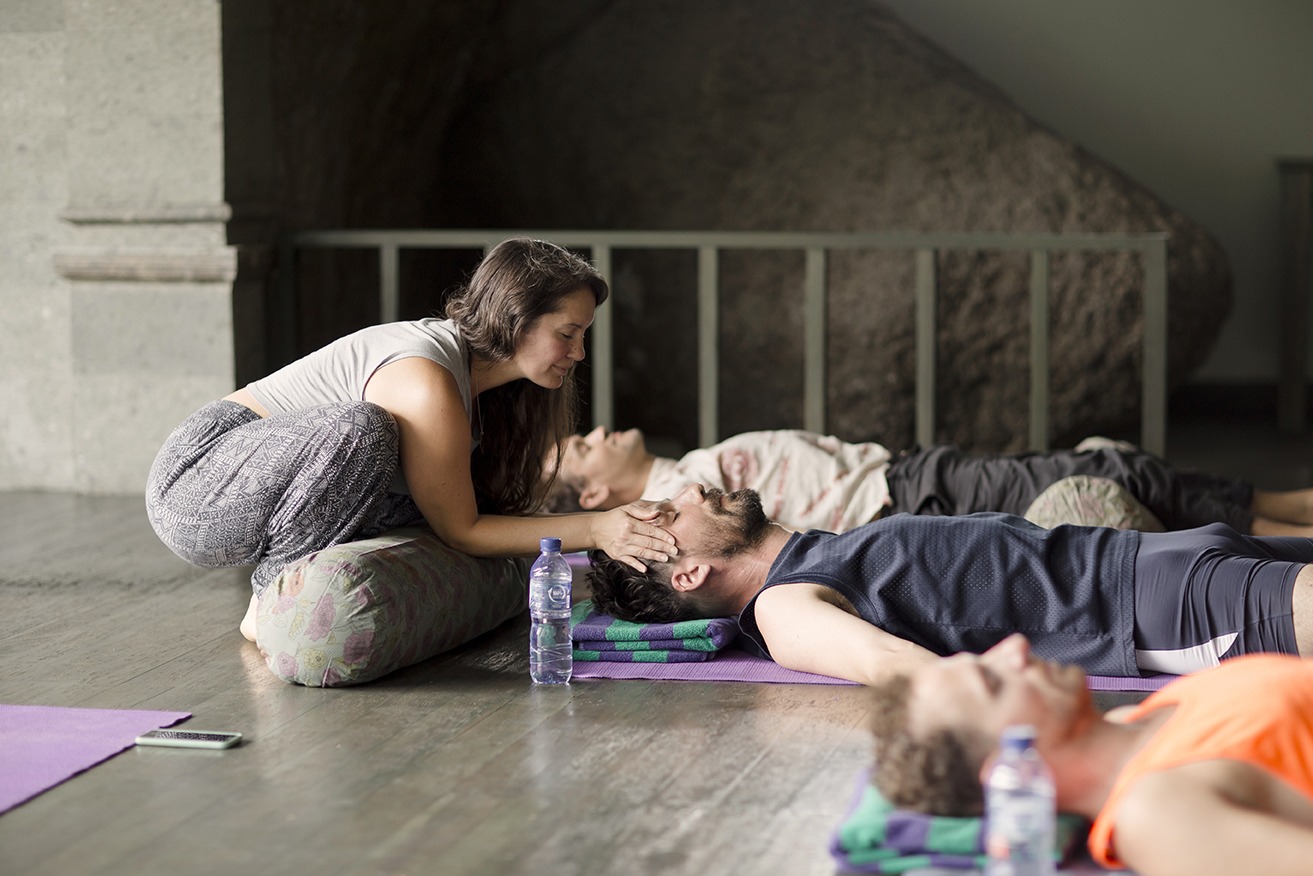 yoga teacher making adjustments at a retreat in Bali