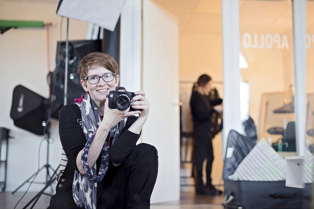 photographer holding her camera in a studio