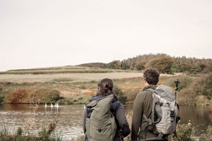 two people look out over lake on hill walk